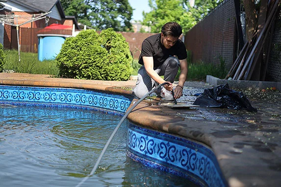 Pool service technician cleaning a pool