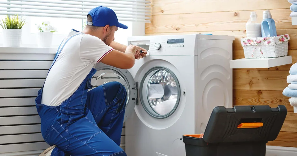 Appliance repair technician fixing a washing machine