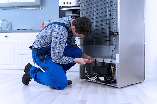 Technician repairing a refrigerator