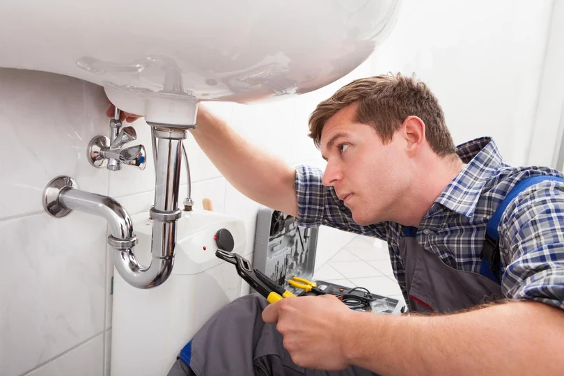 Plumber fixing a sink during a service call