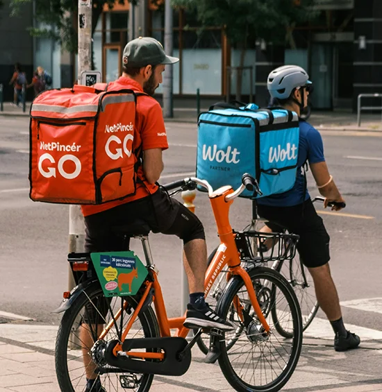 Two delivery drivers on bikes