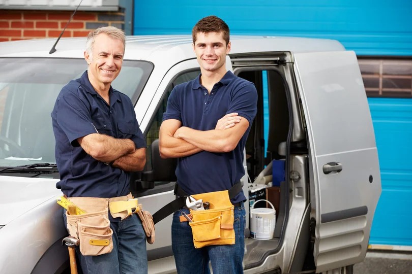 Two plumbers standing together ready for service calls